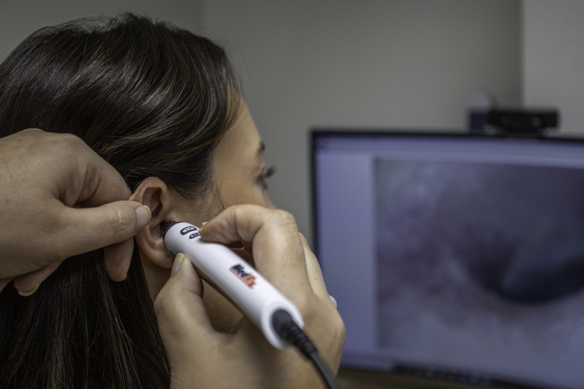 Doctor of Audiology fitting a hearing aid